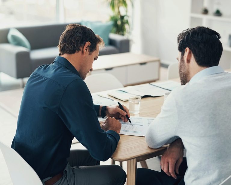 Two professional workers discussing paperwork together